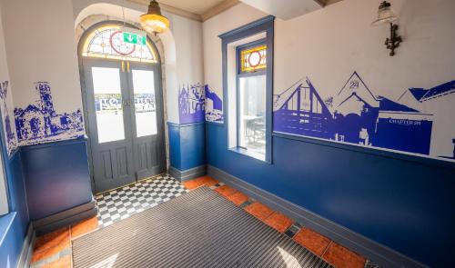 a hallway with blue walls and windows and a door at Temple Gate Hotel in Ennis