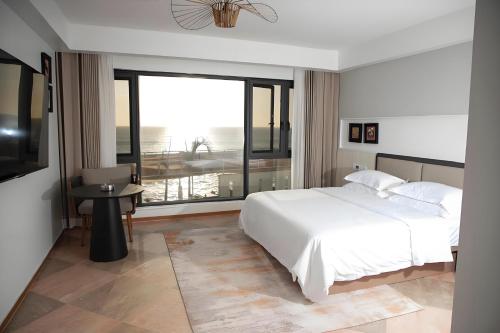 a bedroom with a white bed and a large window at Jardin d'orient in Dakar