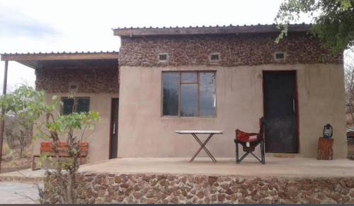 a house with a table in front of it at Pop Lamont Camp in Chobe