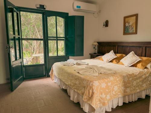 a bedroom with a bed and a large window at Finca La Media Luna in San Agustín de Valle Fértil