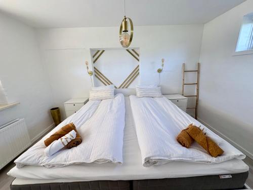 a bedroom with two beds with white sheets at Lejlighed Edelweiss in Svendborg