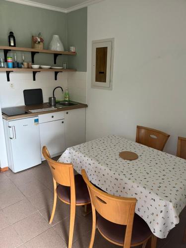 a kitchen with a table and some chairs and a table and a kitchen with at Dömös Danu Kemping in Dömös