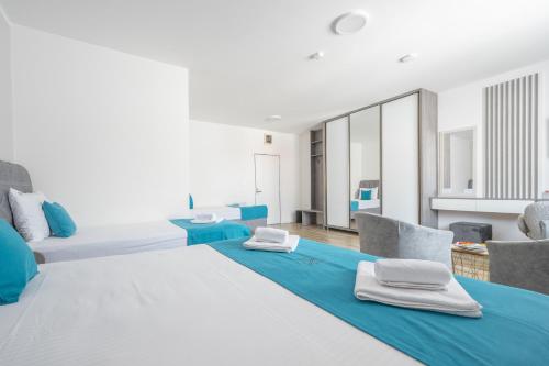 two beds in a room with blue and white at Hotel Mondo in Budva