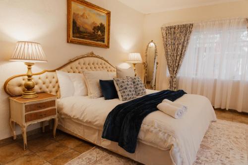 a bedroom with a bed with pillows on it at The Hidden Garden Guesthouse in Meyerton