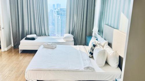 a hotel room with two beds and a large window at Platinum Astern SUITES by KLCC in Kuala Lumpur