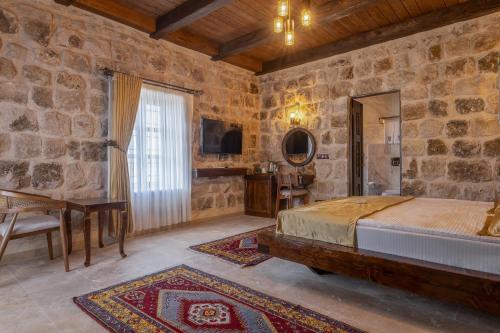 a bedroom with a bed and a stone wall at Noble Blue Cappadocia in Ortahisar