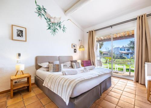a bedroom with a large bed and a large window at Hotel La Tramontane in Saintes-Maries-de-la-Mer
