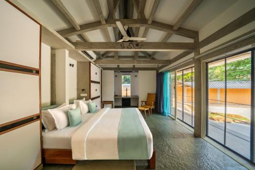 a bedroom with a large bed in a room at Sanctuary Amaidiyana - A CGH Earth Experience in Pondicherry