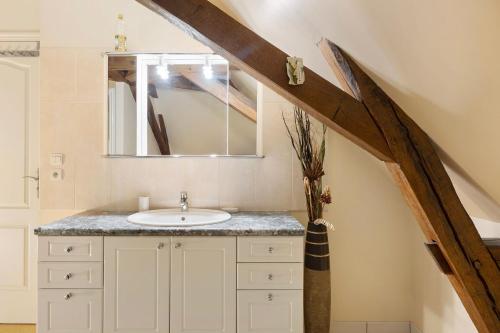 a bathroom with a sink and a mirror at Gîte La Clématite in Mosnes