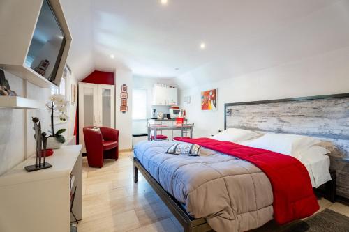 a bedroom with a large bed and a red chair at La Cour Des Amis in Vendenheim