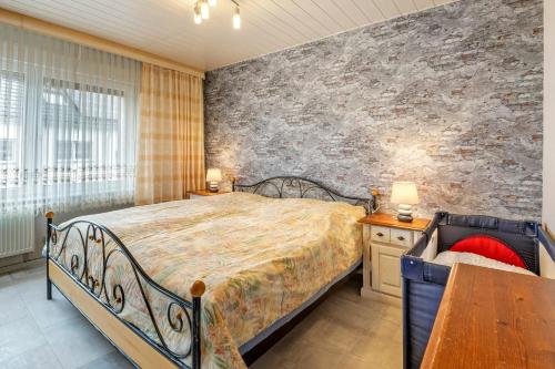 a bedroom with a bed and a stone wall at Familienhaus mit riesigem Garten in Arnsdorf