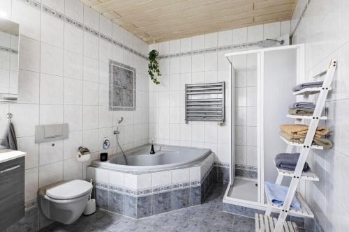 a bathroom with a tub and a toilet and a sink at Familienhaus mit riesigem Garten in Arnsdorf