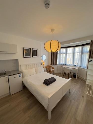 a bedroom with a large white bed and a kitchen at Spacious 3 Guests Ensuite Room,Piccadilly Line,Fast Access Central London 1 in London