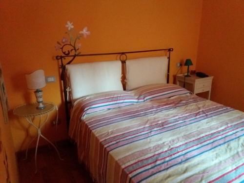a bed with a striped bedspread in a bedroom at Il Vicolo in Cagli