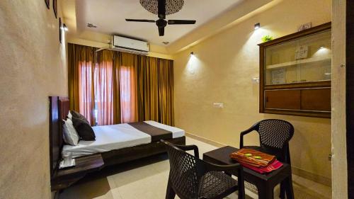 a bedroom with a bed and a table and a chair at Shivalay Premium Homestay in Ujjain