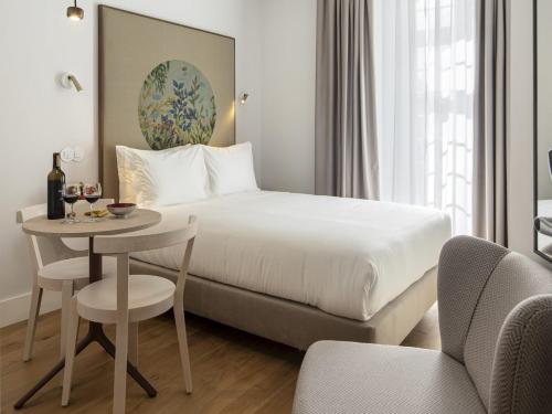 a hotel room with a bed and a table and chairs at LSA Madalena by Numa in Lisbon