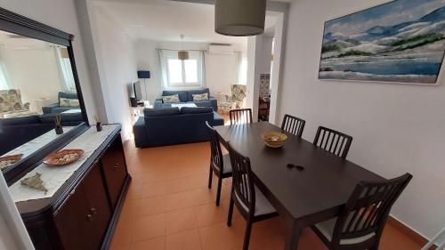 a dining room and living room with a table and chairs at Casa Feliz Obidos Lagoon and sea view in Foz do Arelho