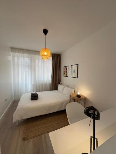 a bedroom with a white bed and a table at Modern Private Ensuite Room,Piccadilly Line,Stylish & Quiet Stay 2 in London