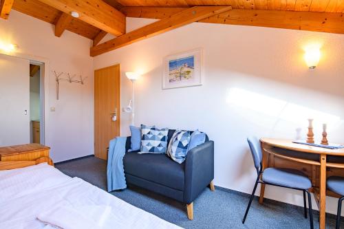 a bedroom with a bed and a table and a chair at Haus Seewind Warnemünde in Rostock