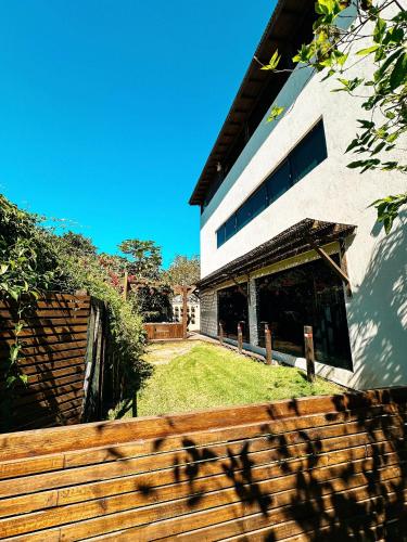 a house with a wooden fence in front of it at Sheeps Family - Loft, Casa e Apartamento para Temporada - Praia do Rosa in Praia do Rosa