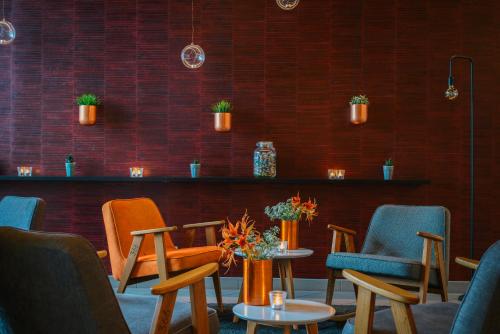 a group of chairs and tables in a room at Vienna House Easy by Wyndham Neckarsulm in Neckarsulm
