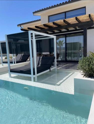 a house with a swimming pool and a pergola at Villa Relax in Kallithea Halkidikis