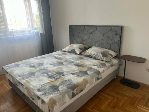 a bedroom with a bed with a gray headboard at Saric LuxApartman in Kruševac
