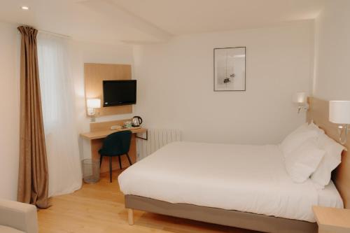 a hotel room with a white bed and a desk at Kyriad Quimper Sud in Quimper