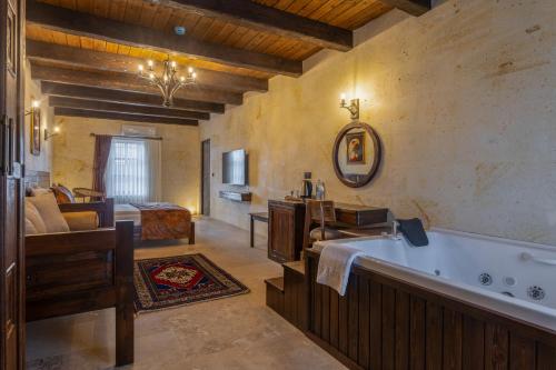 a large bathroom with a tub and a bedroom at Noble Blue Cappadocia in Ortahisar