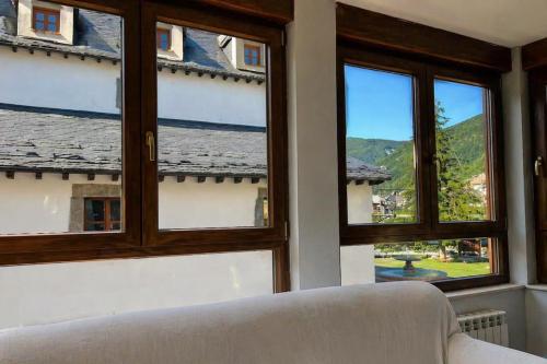 a living room with windows and a white couch at Biescas Suites in Biescas