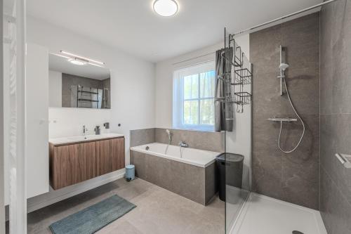 a bathroom with a tub and a sink and a shower at vakantiewoning T'is ier goed in Jabbeke