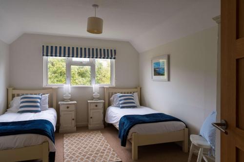 a small bedroom with two beds and a window at White Sands in Croyde