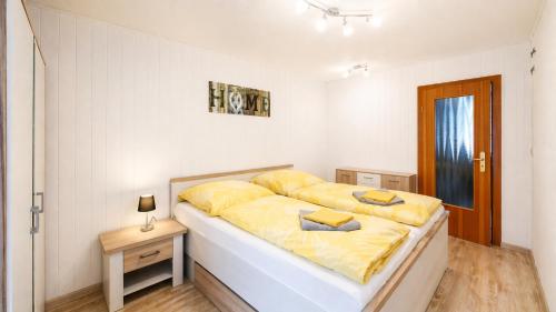 a bedroom with a large bed with yellow sheets at Ruhige Ferienwohnung am Fürst-Pückler-Park, Sauna im Haus & Parkplatz Bad Muskau in Bad Muskau