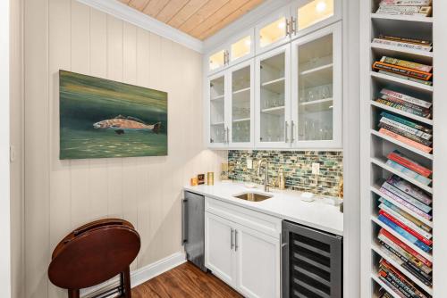 a kitchen with white cabinets and a sink and a chair at Pet Friendly Beachfront Home - Casa Bella Del Sol in Cape San Blas