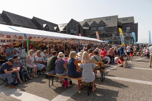 a crowd of people sitting on benches in front of a market at Central Falmouth Flat with Free Parking in Falmouth