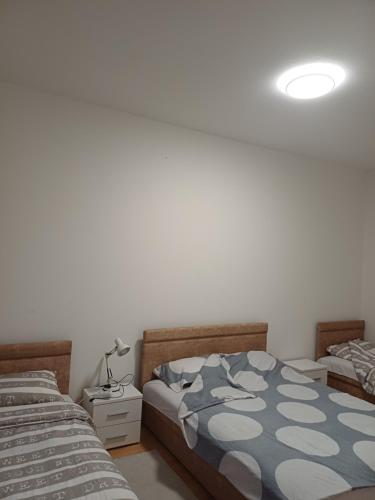 a bedroom with two twin beds and a lamp at Apartman Čerkez in Stolac