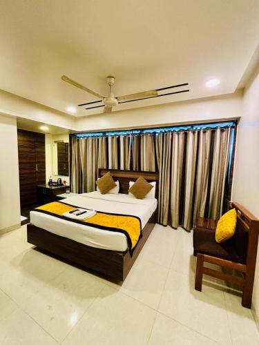 a bedroom with a large bed and a chair at Hotel Silver Seven in Jāmb