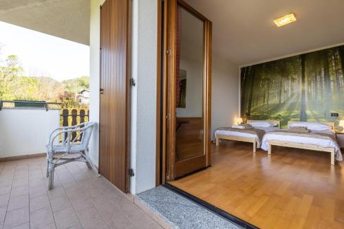 a room with a sliding glass door with two beds at ROSSO DI SERA Bed & Breakfast in Tarcento