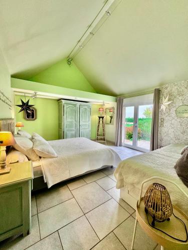 a green bedroom with two beds and a table at Gîte de la Valière in Chevigny-en-Valière