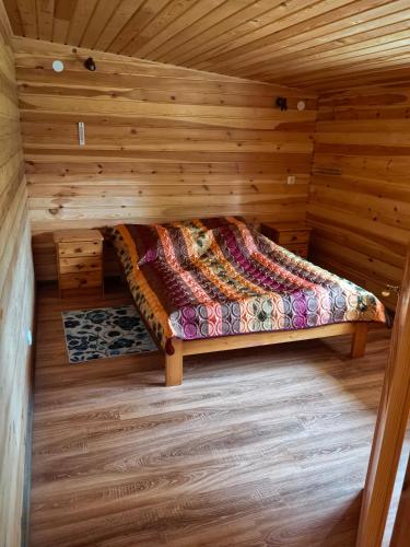a bedroom in a log cabin with a bed at Дом у моря in Suurupi