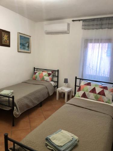 a bedroom with two beds and a window at Il Vicolo in Buti