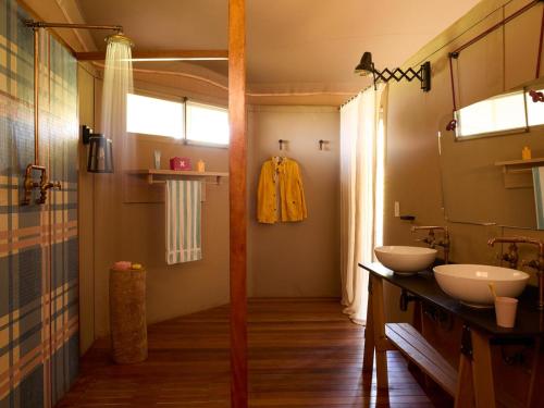 a bathroom with two sinks and a mirror at Camp Canoe in Franschhoek