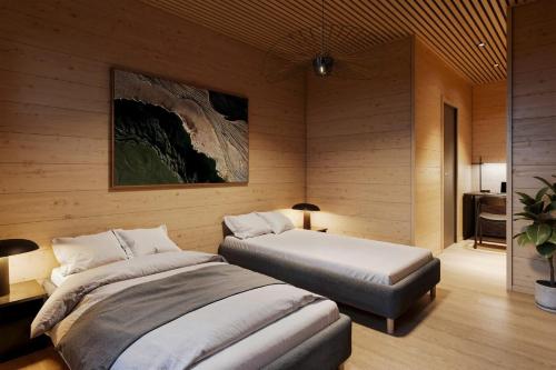 a bedroom with two beds and a painting on the wall at TAHKO LAKESIDE VILLA D 3 in Tahkovuori