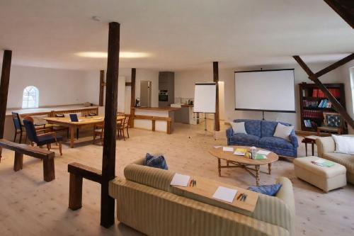 a large living room with couches and a screen at Atelier - Flensburger Förde in Westerholz
