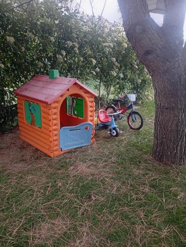 a small house and a motorcycle parked next to a tree at Refúgio Da Pinheira in Marco de Canaveses