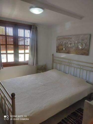 a bedroom with a white bed with a window at Thea apartments 2 in Platamonas