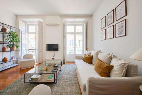 a living room with a white couch and a glass coffee table at MSPC Chiado Premium Apartments in Lisbon