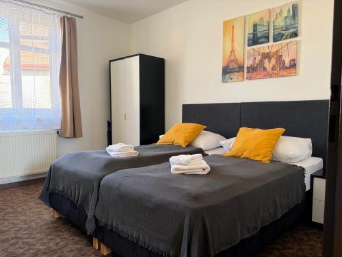 a bedroom with two beds with towels on them at Hotel Pangea in Telč