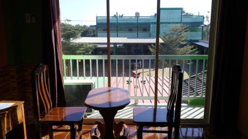 a room with a table and two chairs and a window at Rueangsrisiri Guesthouse 2 in Sukhothai