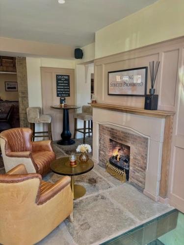 a living room with a fireplace and chairs at The Horse and Farrier Carlisle in Carlisle